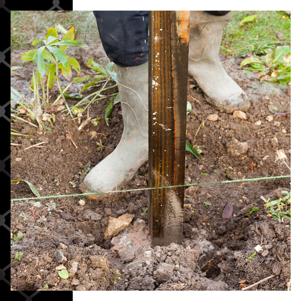 close up of contractor installing fence post