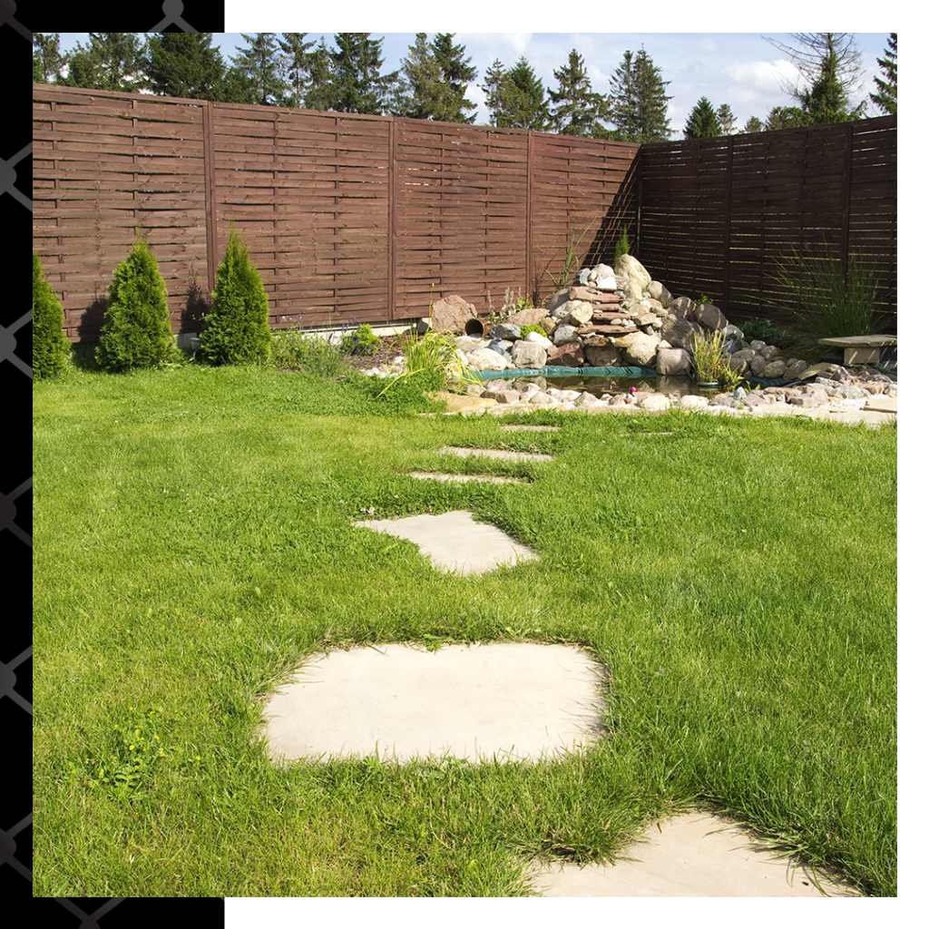 decorative wooden fence surrounding yard with water feature
